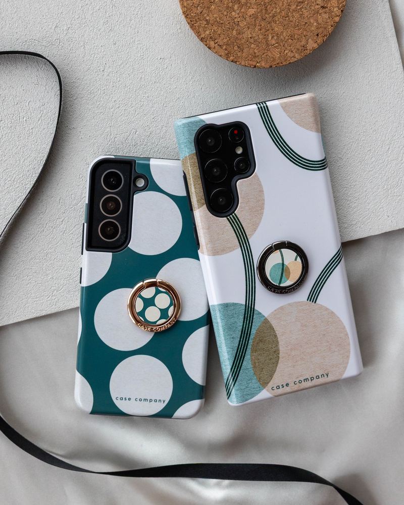 Bagues de téléphone dorée et noire sur des coques à pois et à cercles