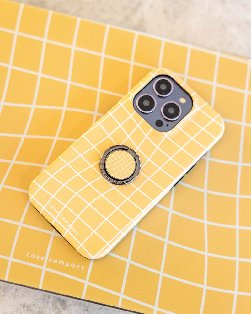 Bague de téléphone noire sur une coque jaune à carreaux
